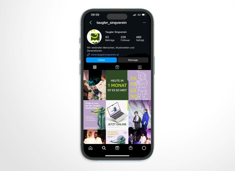 Auf einem Smartphone ist das Instagram-Profil des Taugler Singvereins zu sehen, mit einer Reihe bunter Beiträge, einem grünen Logo und den Schaltflächen „Folgen“ und „Nachricht senden“. Die Uhrzeit auf dem Smartphone zeigt 09:59 Uhr an.